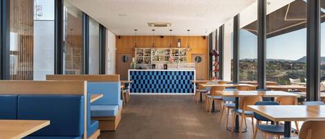 A modern restaurant with wooden booths, blue seating, and a checkered counter.