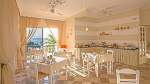 A hotel room with a dining area, a kitchen, and a balcony with a view of the ocean. - Aurora Beach Hotel (Corfu)