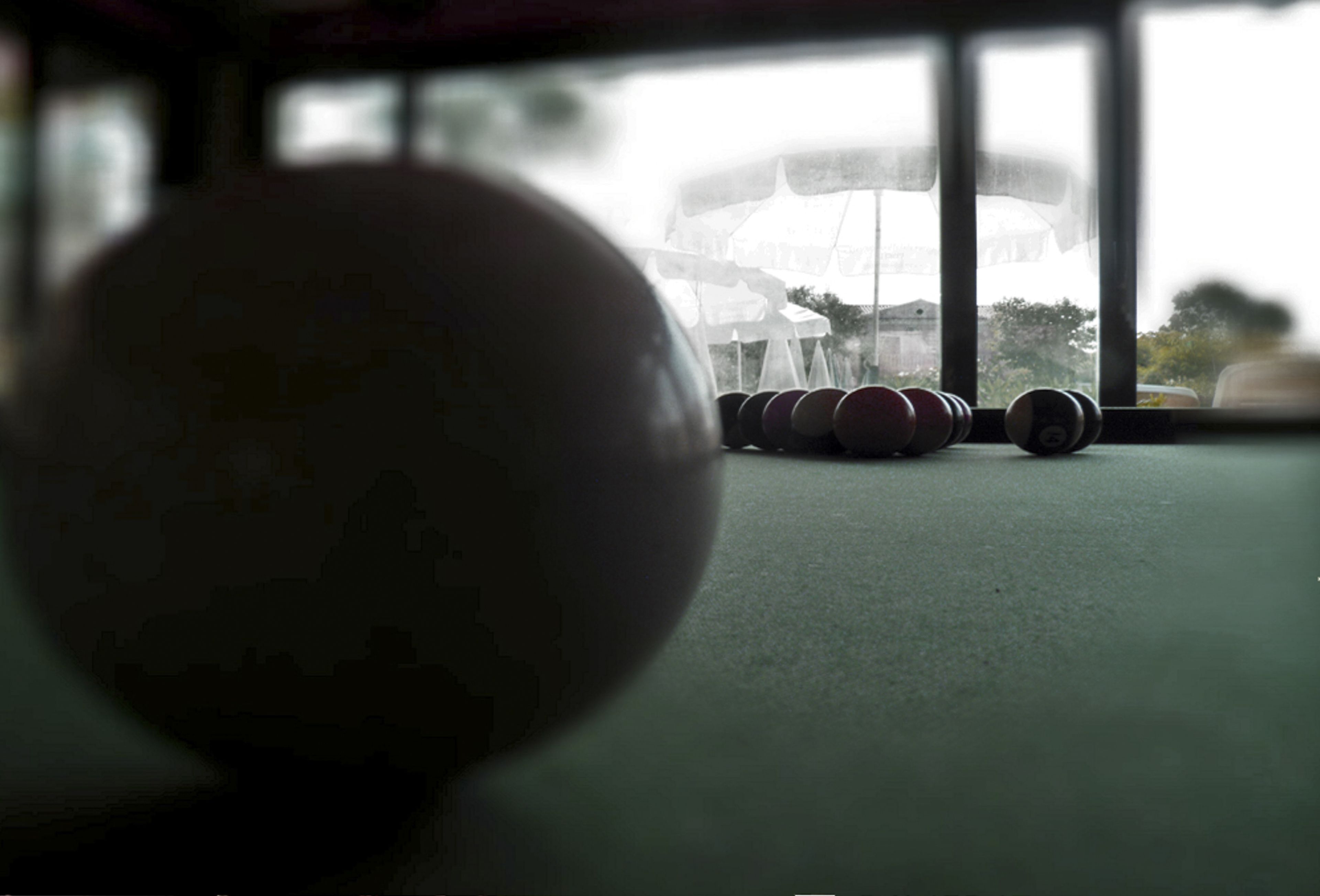 Un gimnasio con una pelota de ejercicios grande al frente y pesas en el fondo.