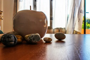 A wooden table with a large ceramic bowl and several smooth stones. - Nireas Resort Corfu (Corfu)