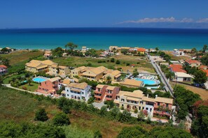 A coastal residential area with multiple buildings, a swimming pool, and a clear view of the sea. - Nireas Resort Corfu (Corfu)
