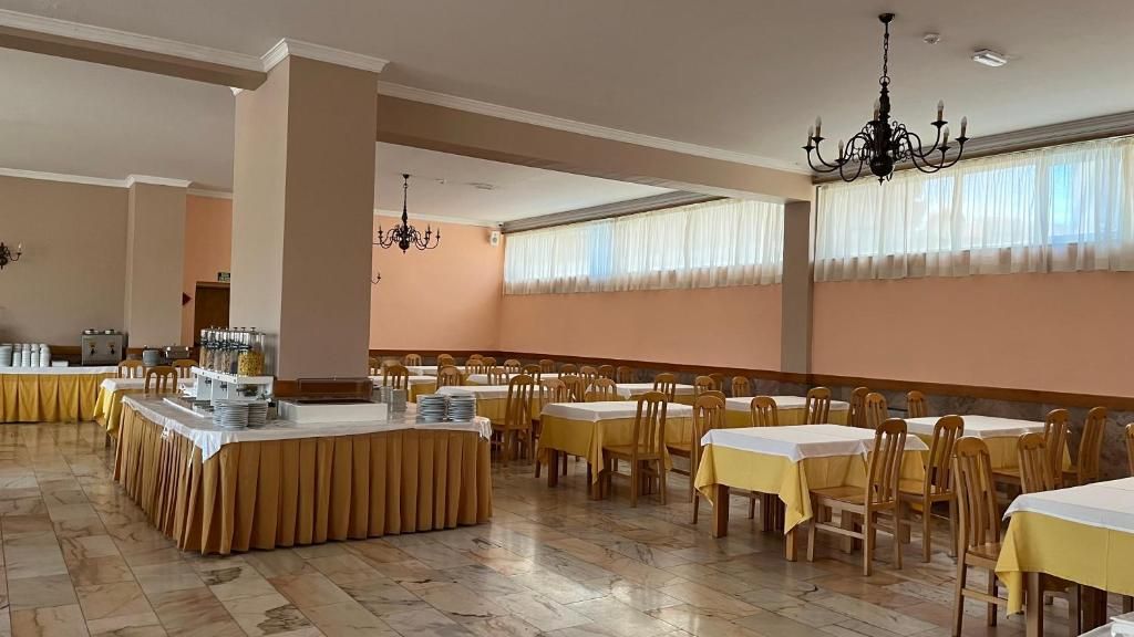 Un comedor con varias mesas, sillas y una mesa de buffet.