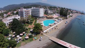 A resort with a swimming pool, beach, and mountain backdrop. - Hotel Rena (Ayvacik)
