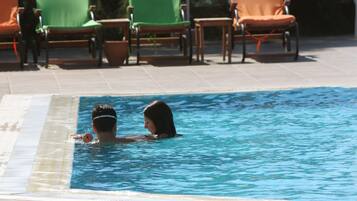 Relax by the pool surrounded by comfortable lounge chairs with cushions.