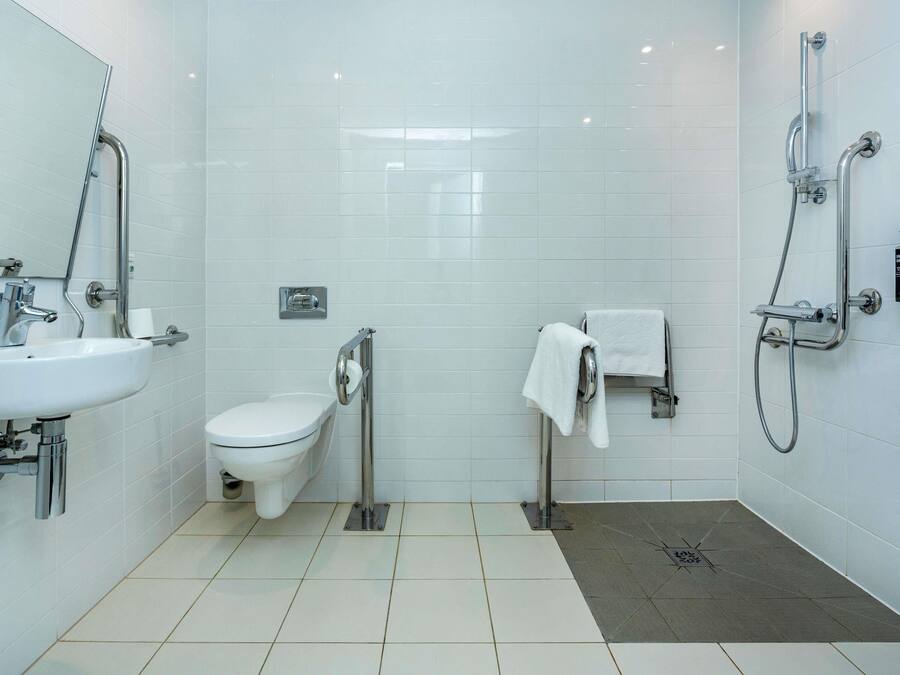 A modern bathroom with a toilet, sink, and shower.