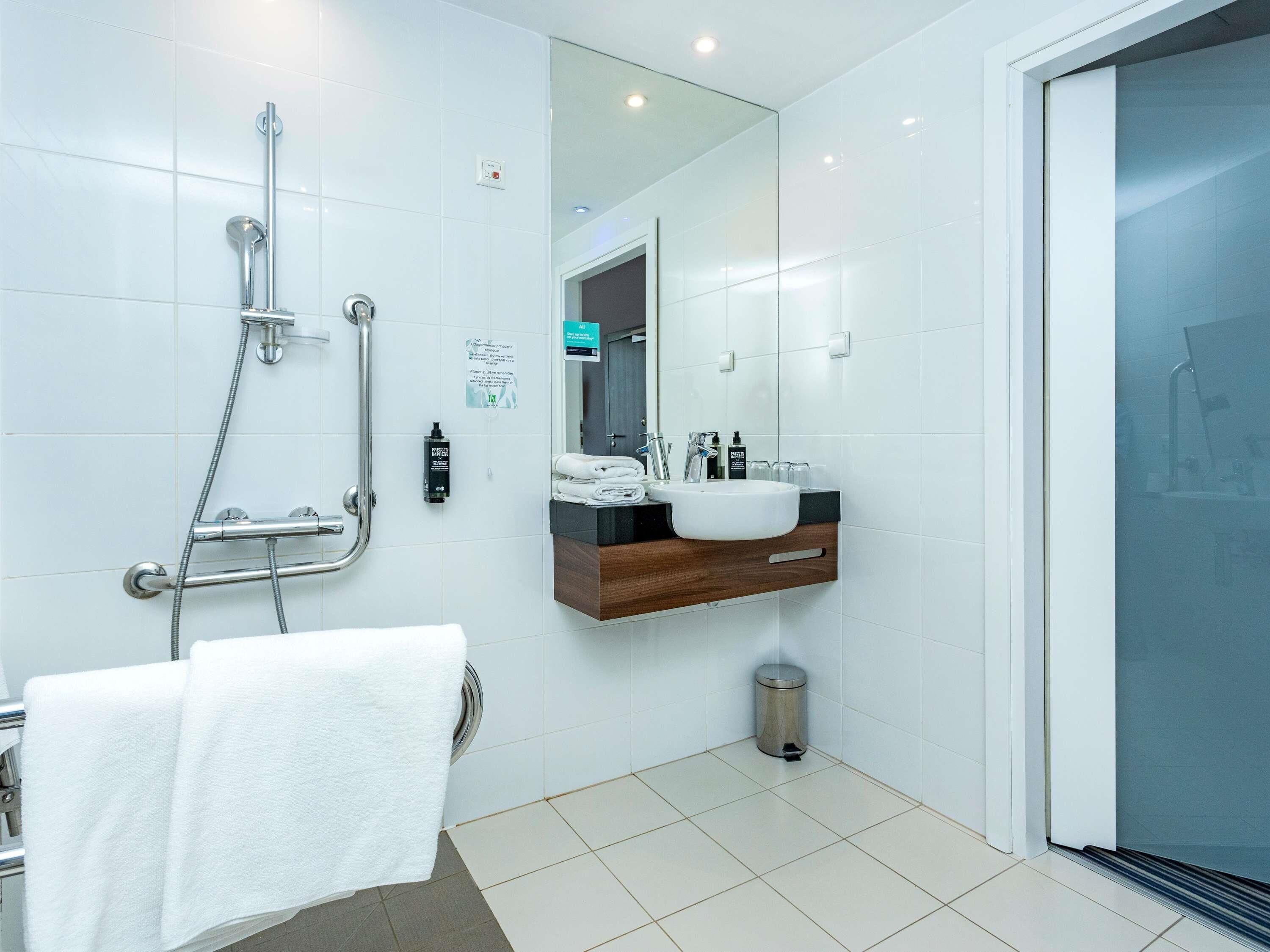 Ein modernes Badezimmer mit Dusche, Waschbecken und Spiegel.