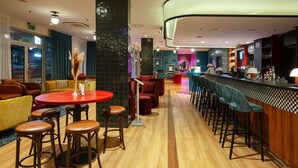 Un área de bar moderna con suelo de madera, taburetes y una barra.