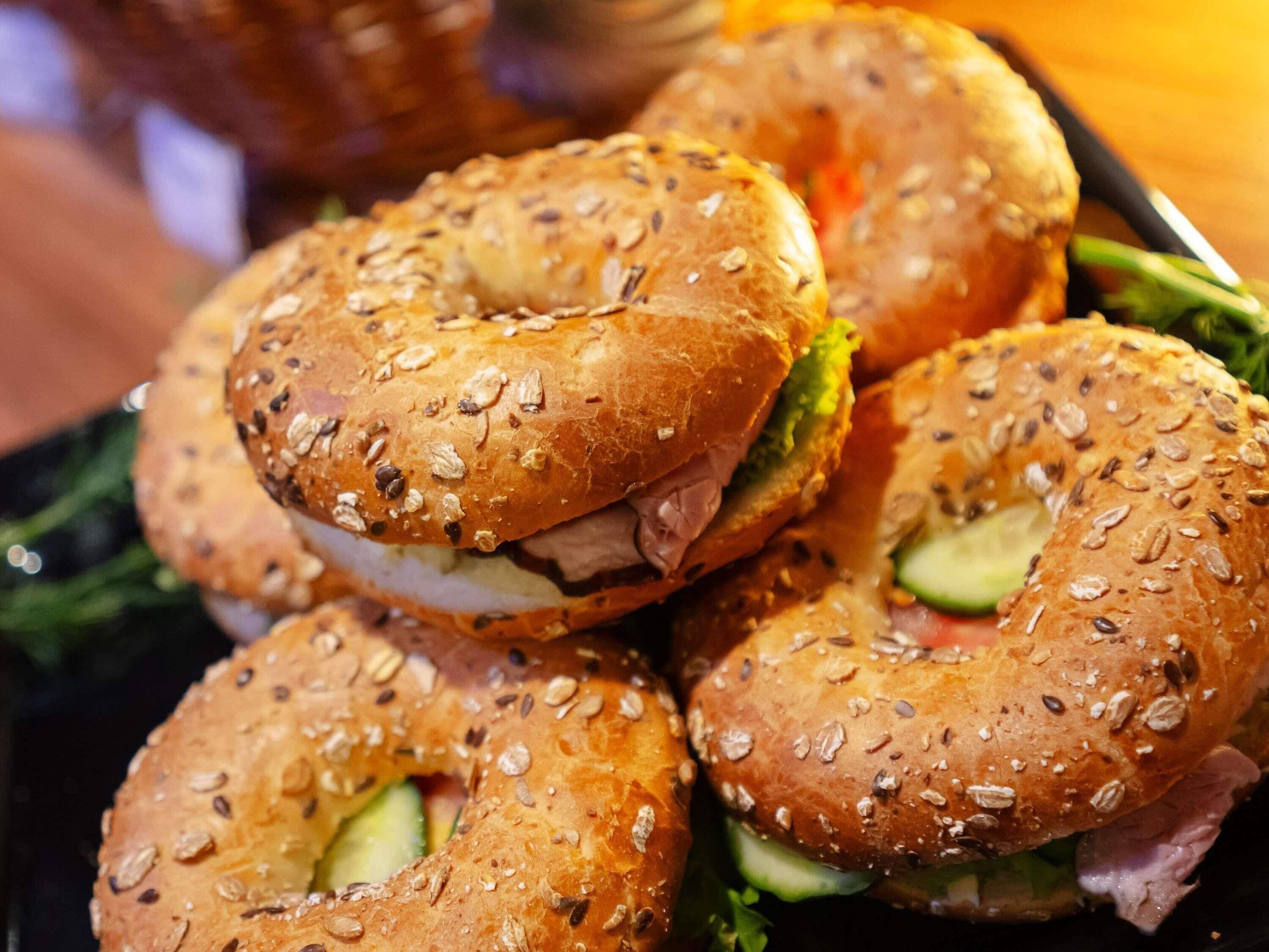 A close-up of bagels with sesame seeds and a sandwich filling.