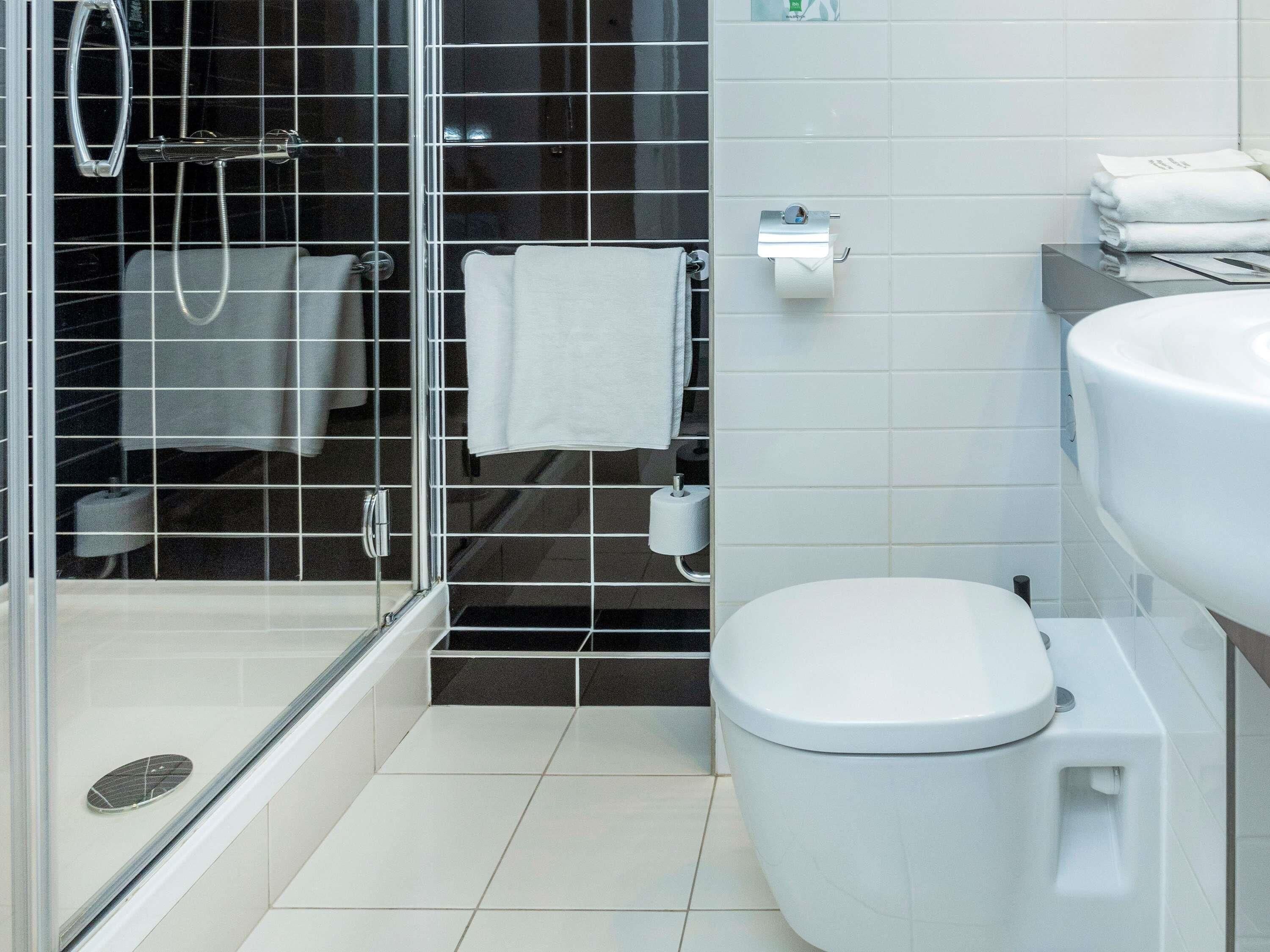 Une salle de bain moderne avec une douche à parois de verre, des toilettes et un lavabo.