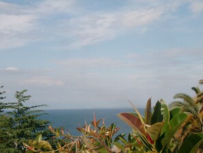 Paesaggio costiero con vista sul mare e sulla terraferma in lontananza.