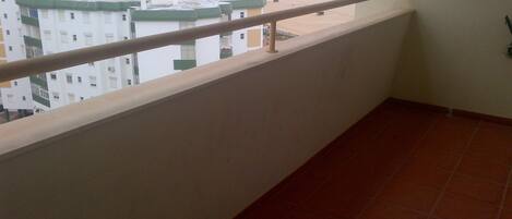 A balcony with a view of a beach and buildings.