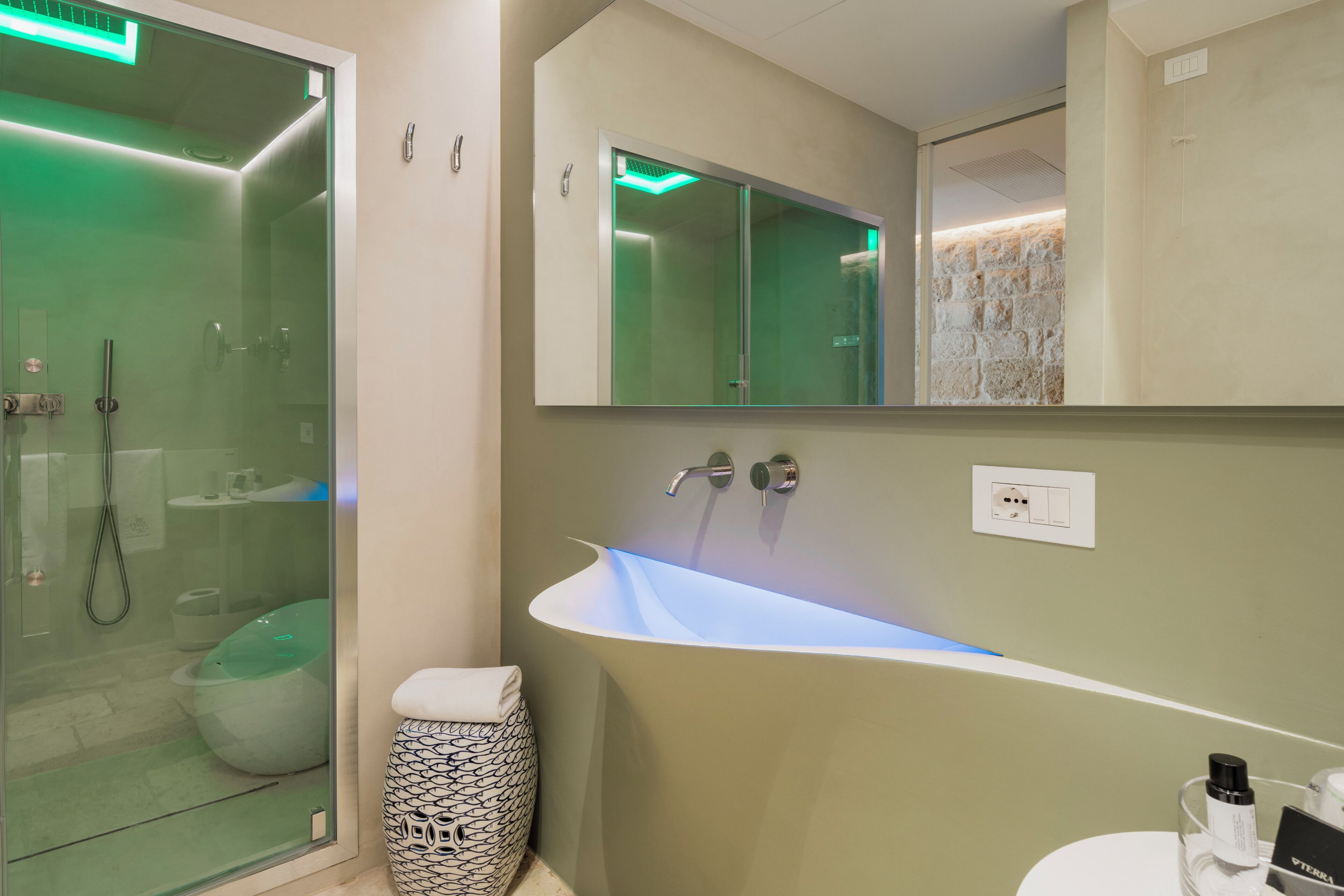 A modern bathroom with a glass-enclosed shower, a freestanding bathtub, and a large mirror above the sink.