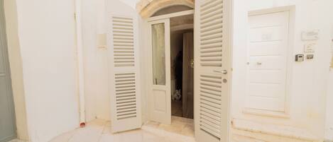 An open door leading to a room with a tiled floor and a stone archway above.
