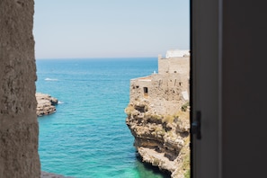 Une vue sur la côte, avec un bâtiment en pierre surplombant la mer.
