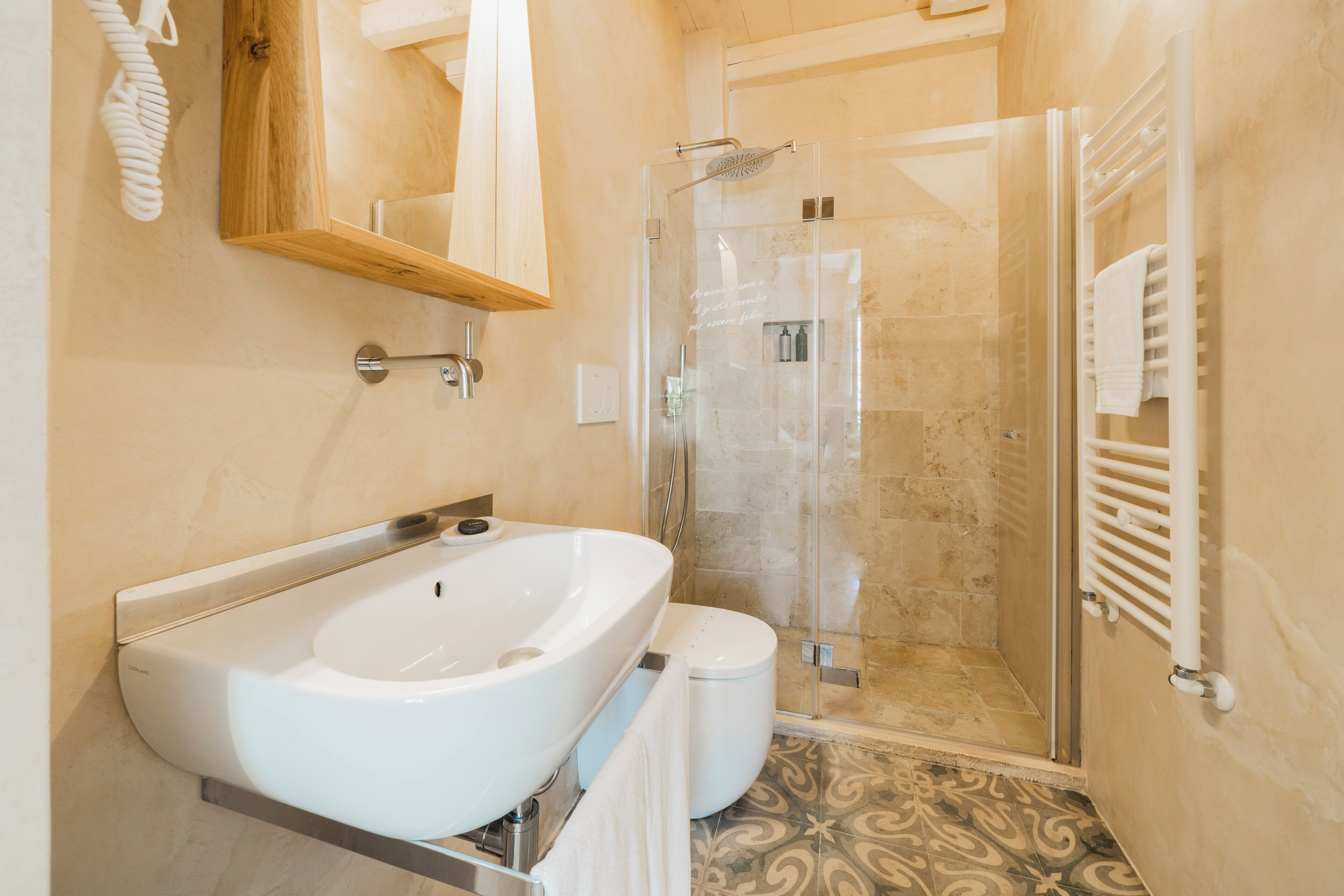 Ein Badezimmer mit einem großen, weißen Waschbecken, einer Toilette und einer Duschkabine.