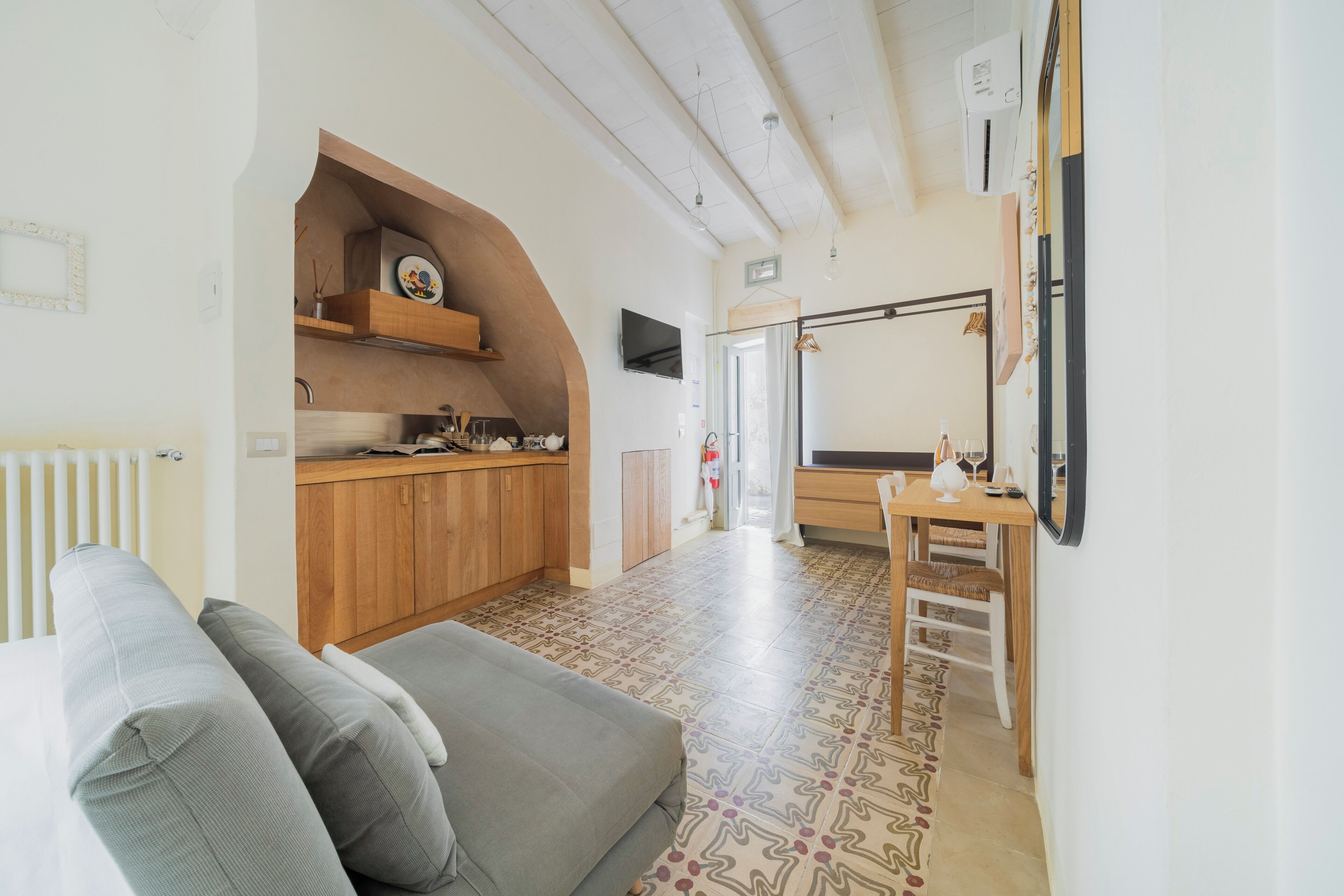 Una cocina moderna con armarios de madera, horno empotrado y comedor con mesa y sillas.