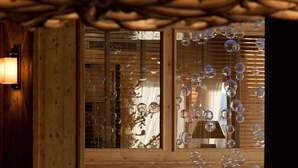 Una escalera con baranda de madera y vistas a una ventana con paneles de vidrio decorativos.