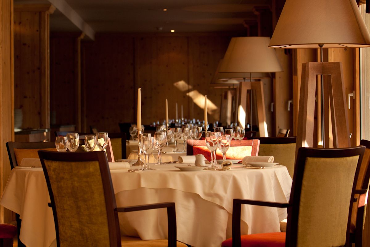 A restaurant with multiple tables set for dining, each with chairs and table settings.
