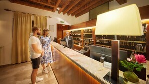 A reception desk with a computer monitor, a cash register, and a telephone. There are wooden bookshelves in the background. - Villas with Balcony or Terrace - Hotel & Resort Adria Ankaran (Ankaran)