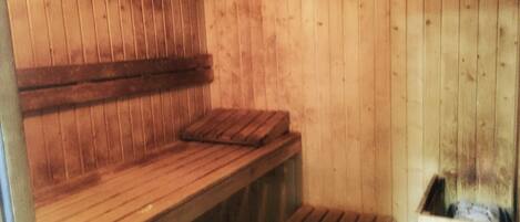 A sauna room with wooden benches and a bench seat.