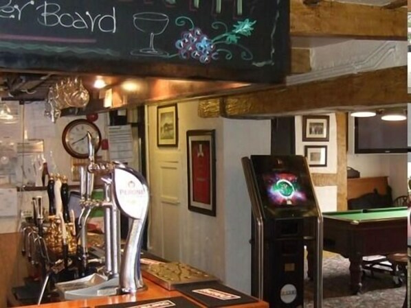 A bar area with multiple beer taps, a pool table, and a chalkboard with 'Beer Board' written on it.