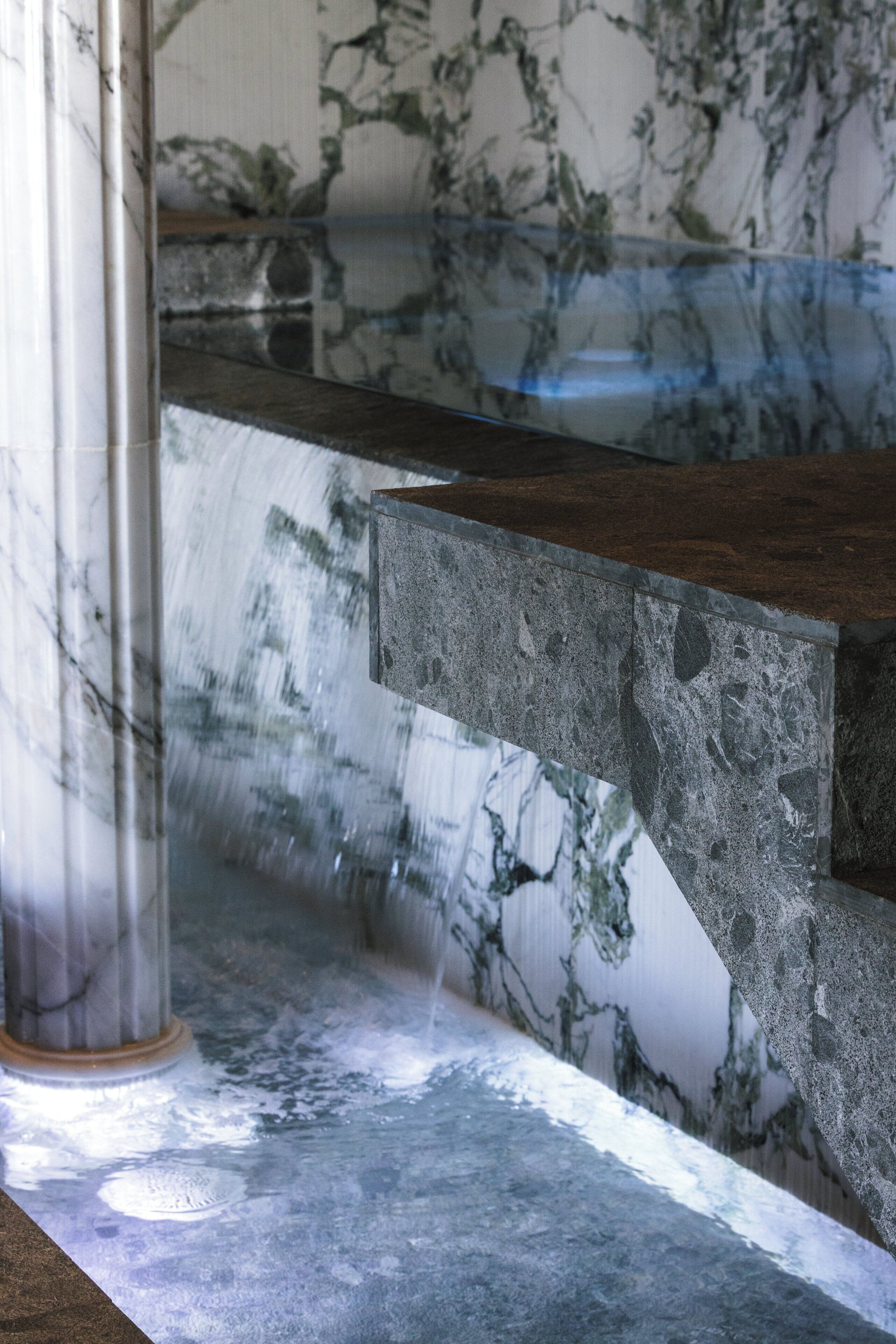 A marble-tiled wall with a water feature.
