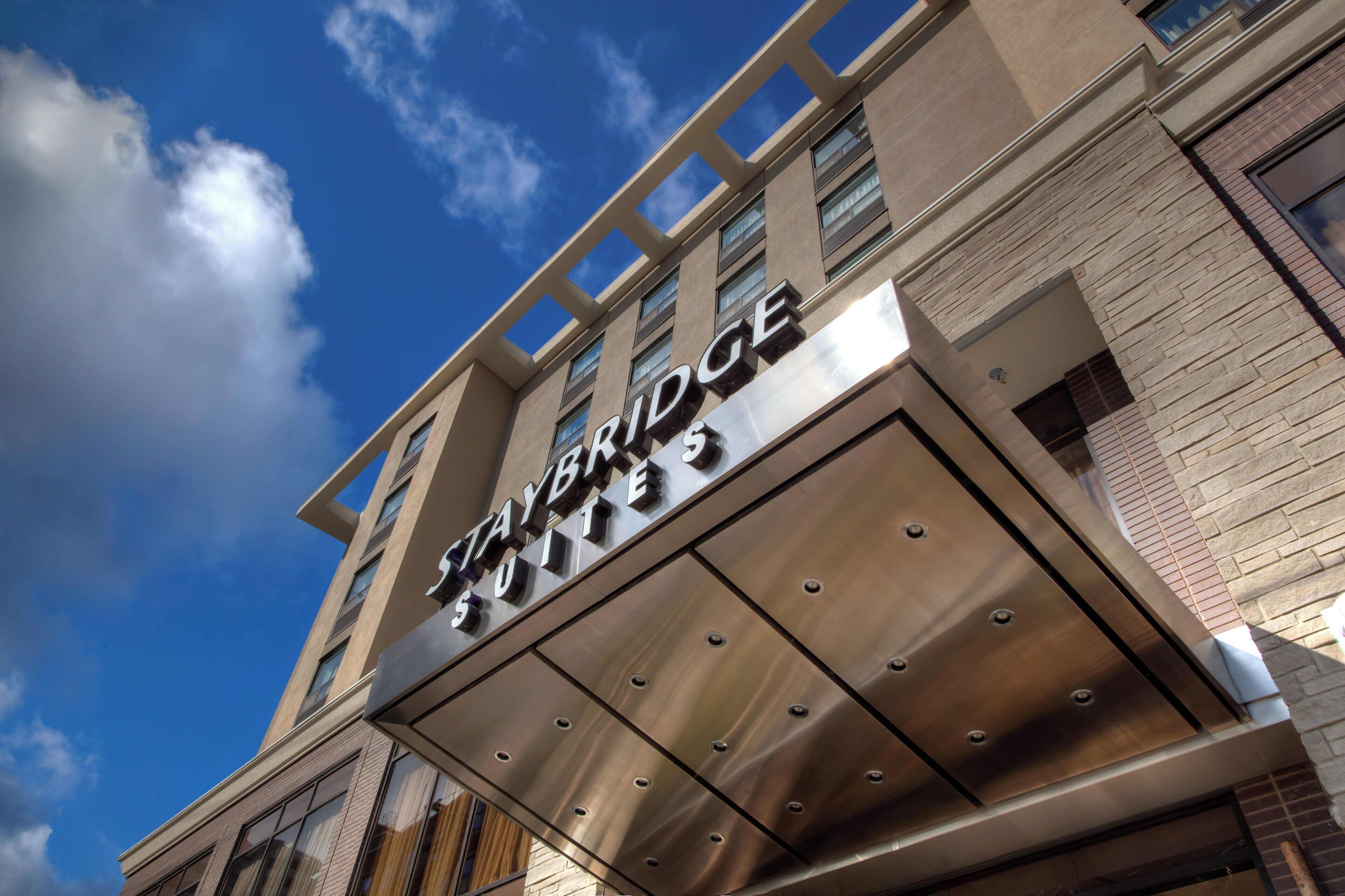 A building with a sign that reads 'Cambridge Suites.'
