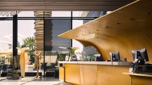 A reception area with a modern design, featuring a reception desk, computers, and seating. - Scandic Fornebu (Bærum)