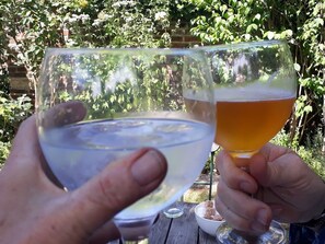 Two people holding glasses of beer and water outdoors. - One Holyrood Hotel (Newport)