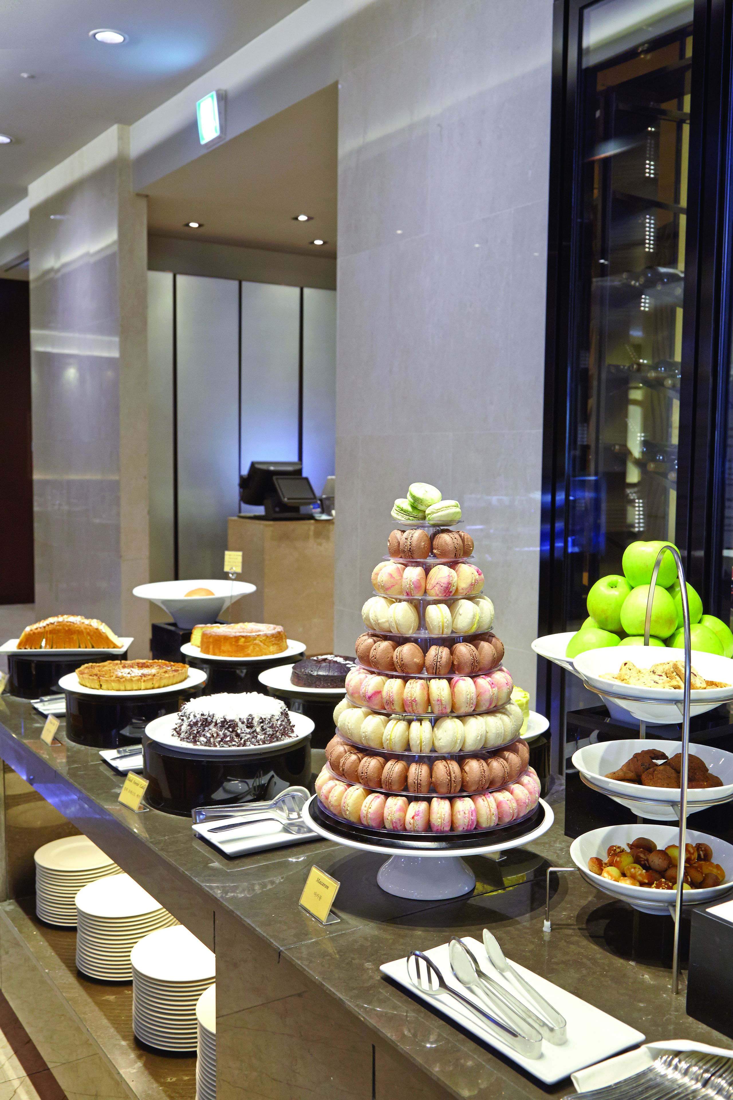 A buffet with various desserts and a tiered display of macarons.