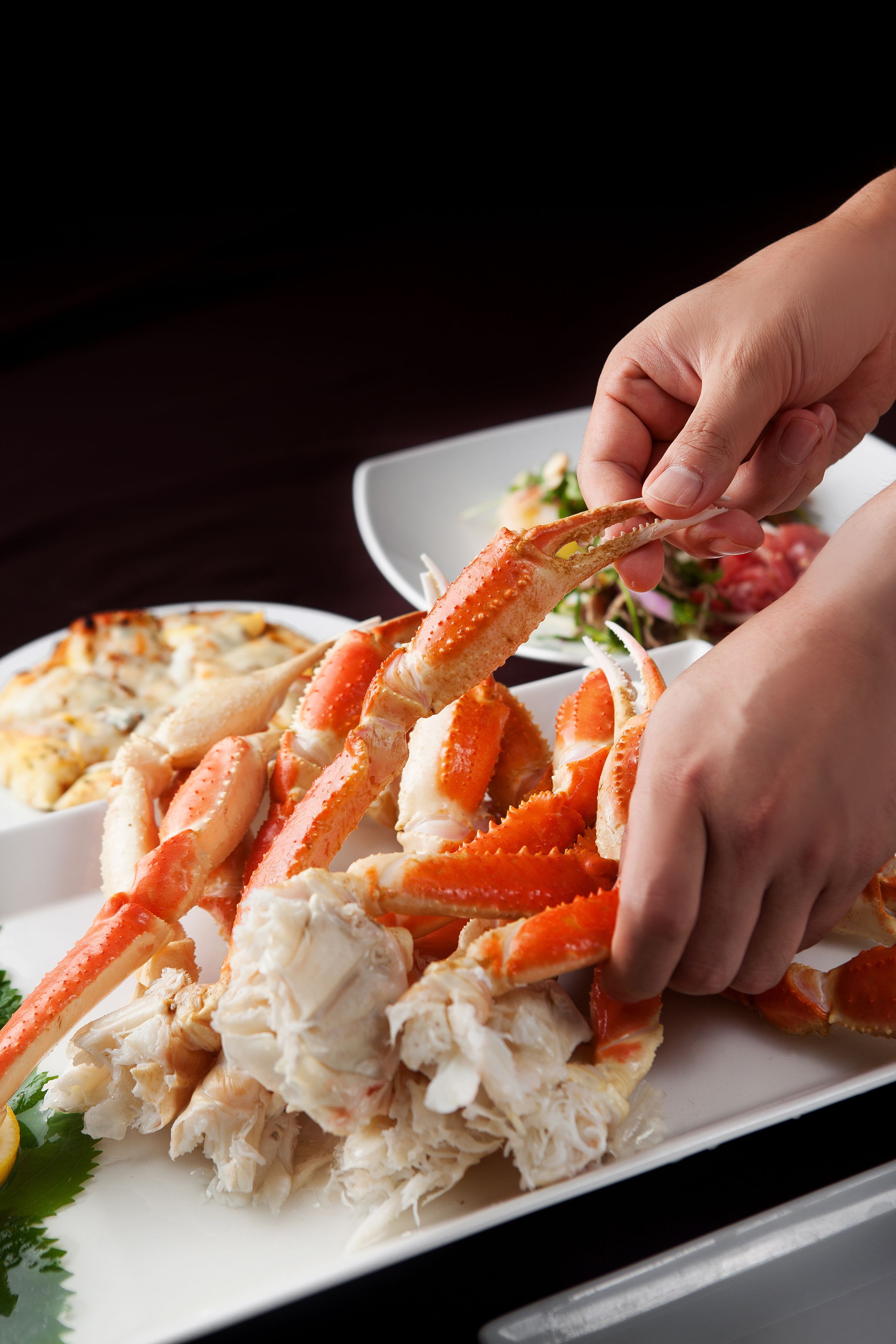 A person holding a large crab leg.