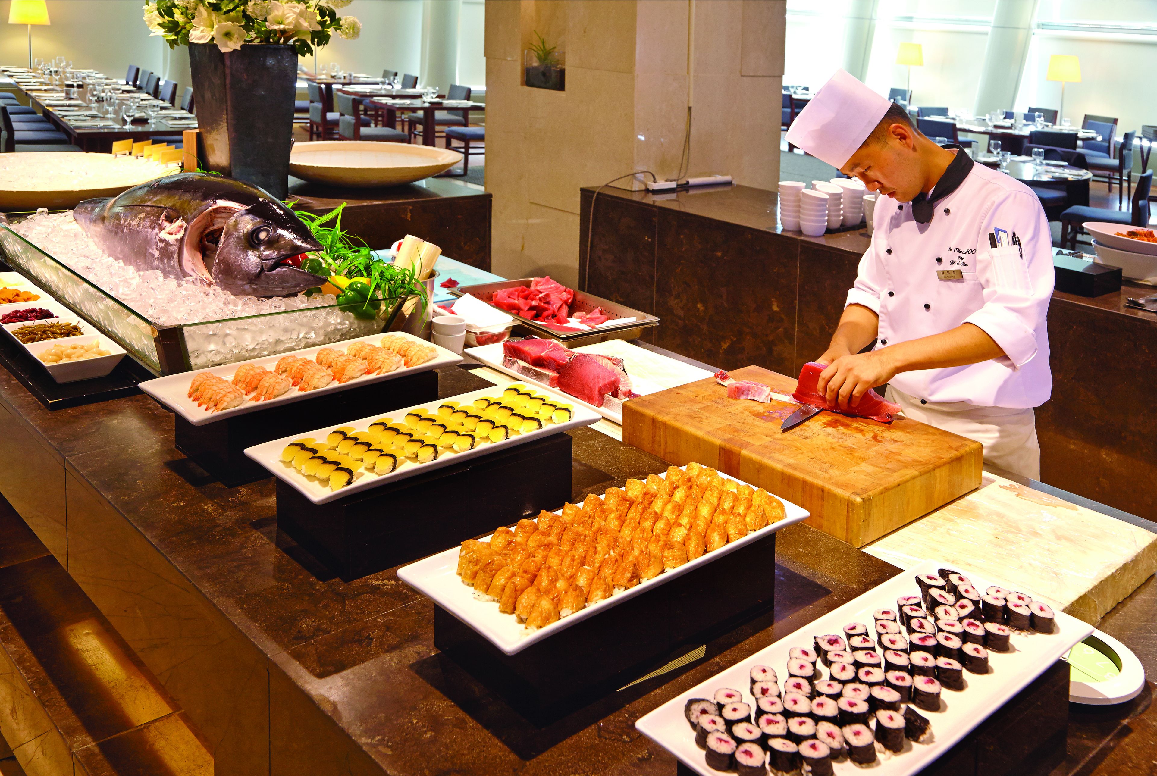 A buffet with various food items including sushi, sashimi, and seafood.