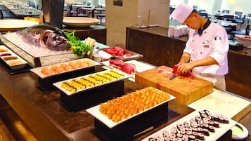 A buffet with various food items including sushi, sashimi, and seafood.