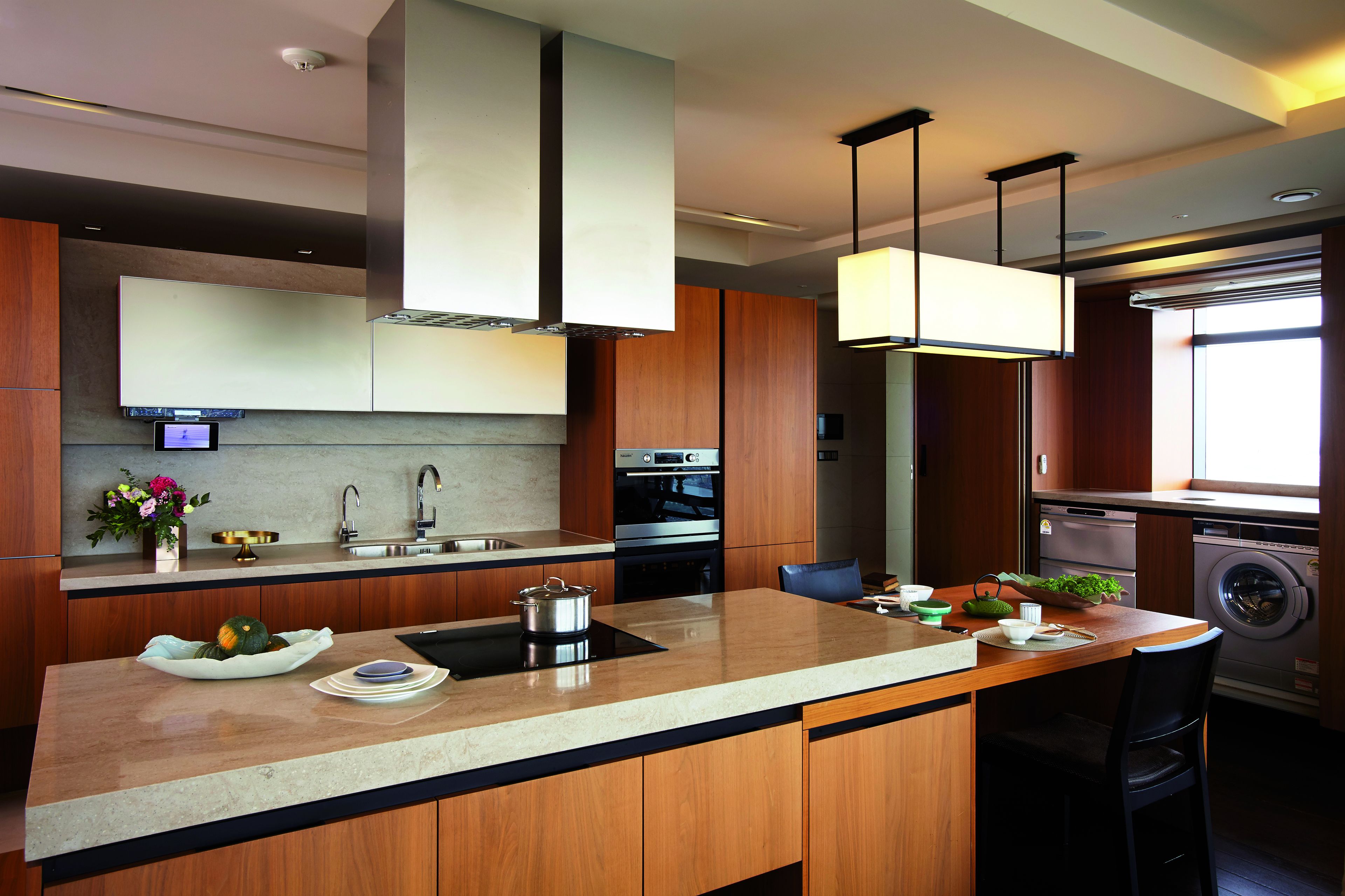 Una cocina moderna con una isla central, electrodomésticos de acero inoxidable y armarios de madera.
