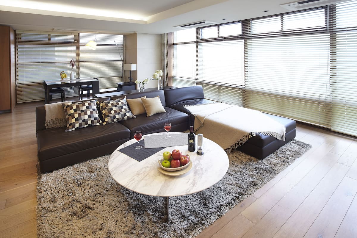 A modern living room with a sofa, coffee table, and dining area.