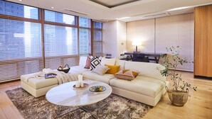 A modern living room with a sofa, coffee table, and a potted plant.