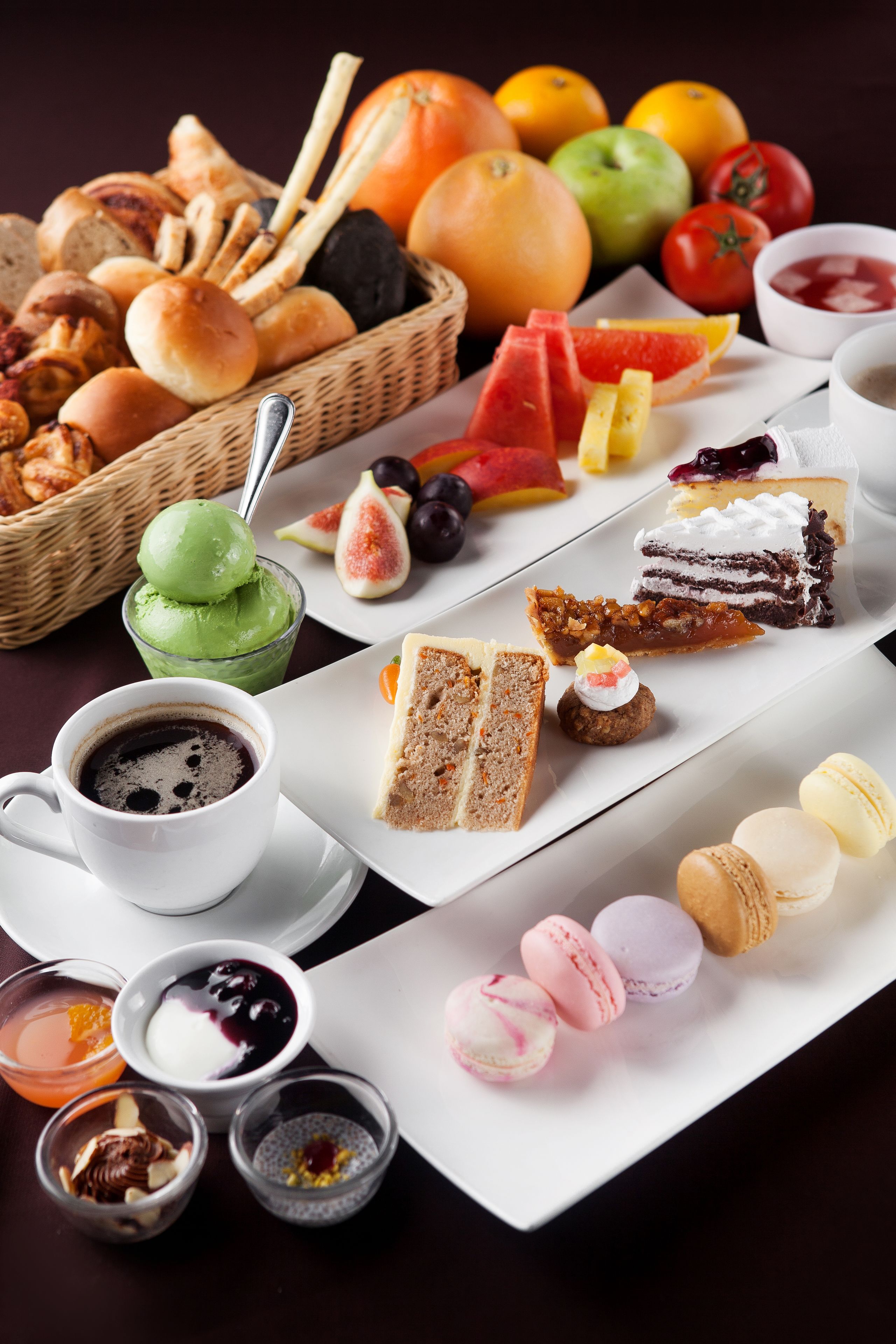 Una variedad de alimentos, incluyendo pasteles, frutas y postres, dispuestos sobre una mesa.
