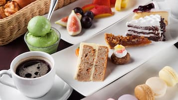Una variedad de alimentos, incluyendo pasteles, frutas y postres, dispuestos sobre una mesa.