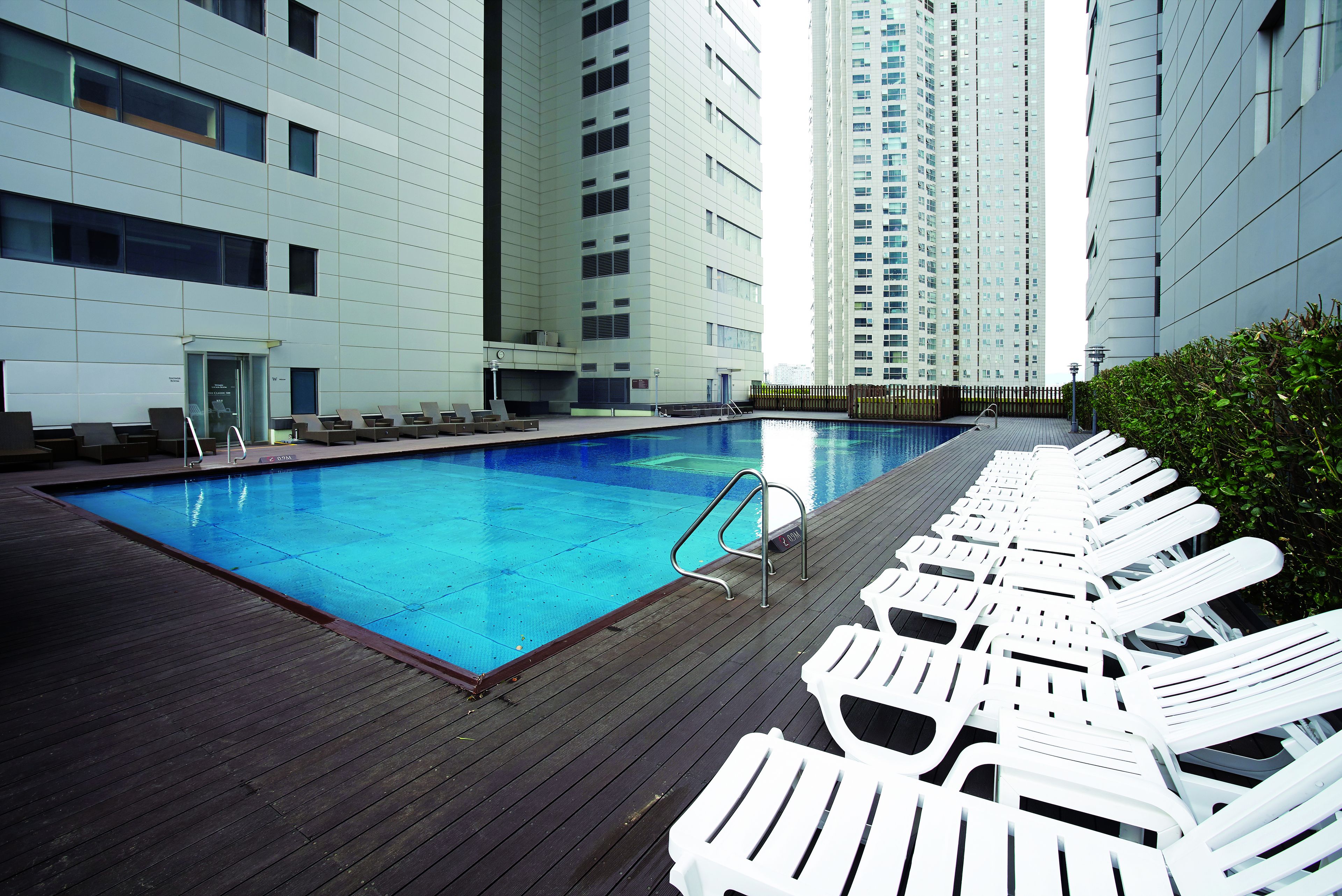 A swimming pool with lounge chairs and a wooden deck.
