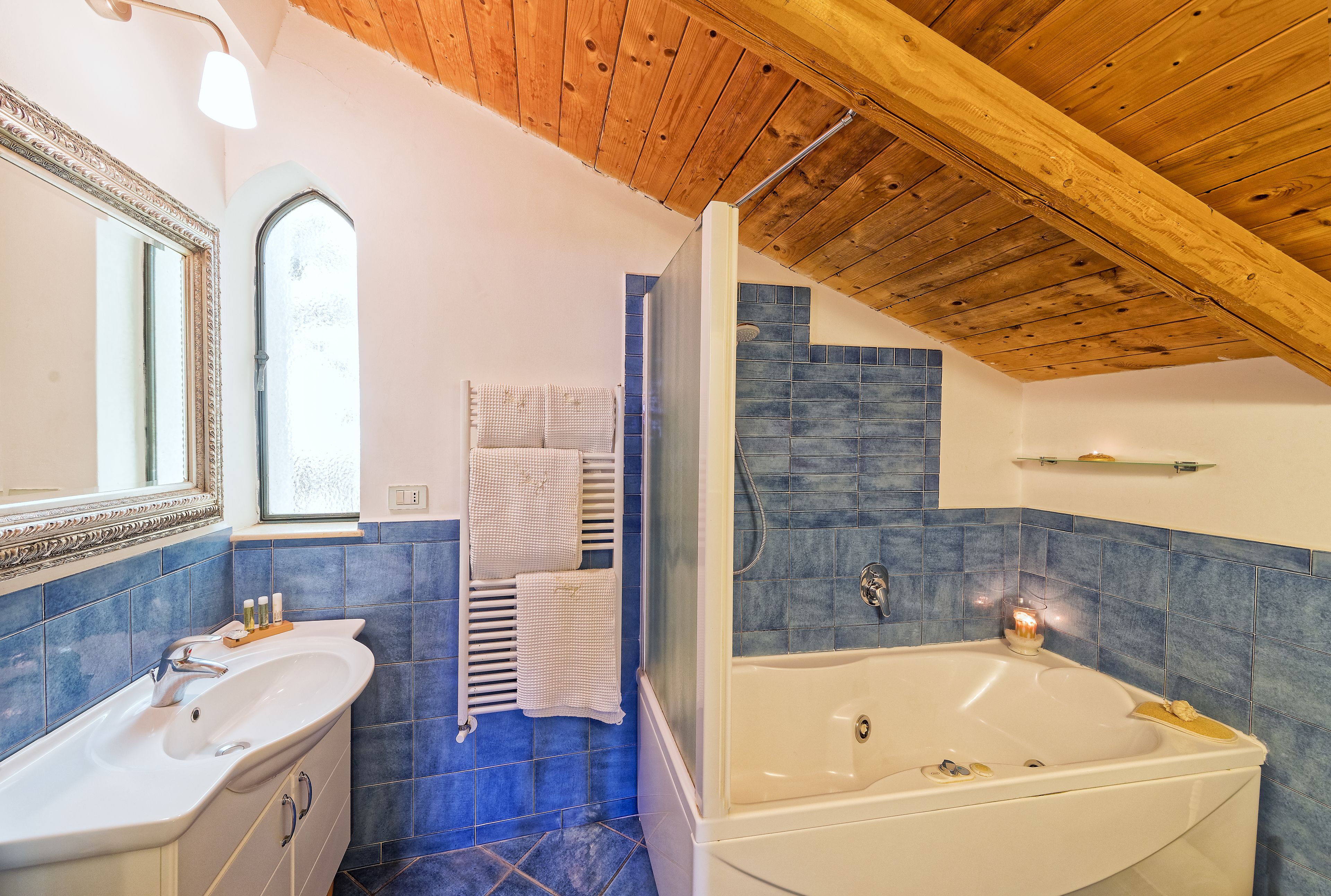 A bathroom with a large bathtub, a sink, and a mirror.