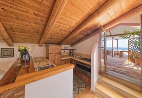 Cozinha de madeira com vista para um pátio.