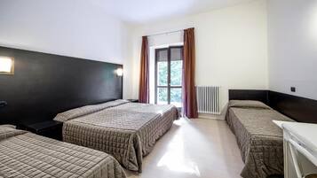 Una camera d'albergo con due letti, una scrivania e una finestra con tende.