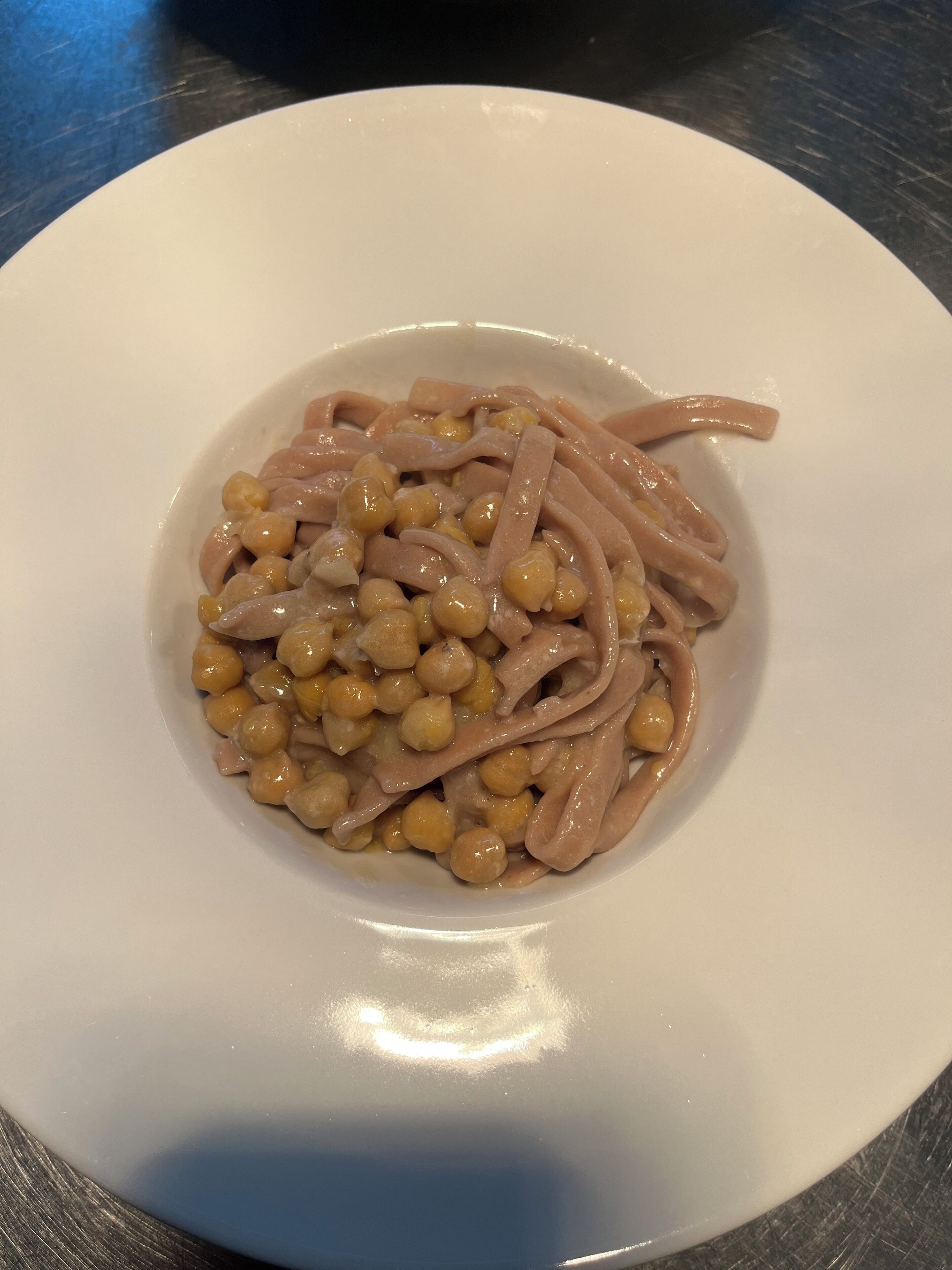 A white plate with a serving of pasta and chickpeas.