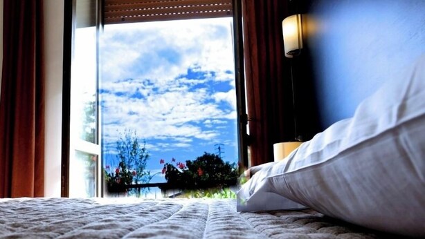 Una cama con vistas al cielo a través de una ventana.