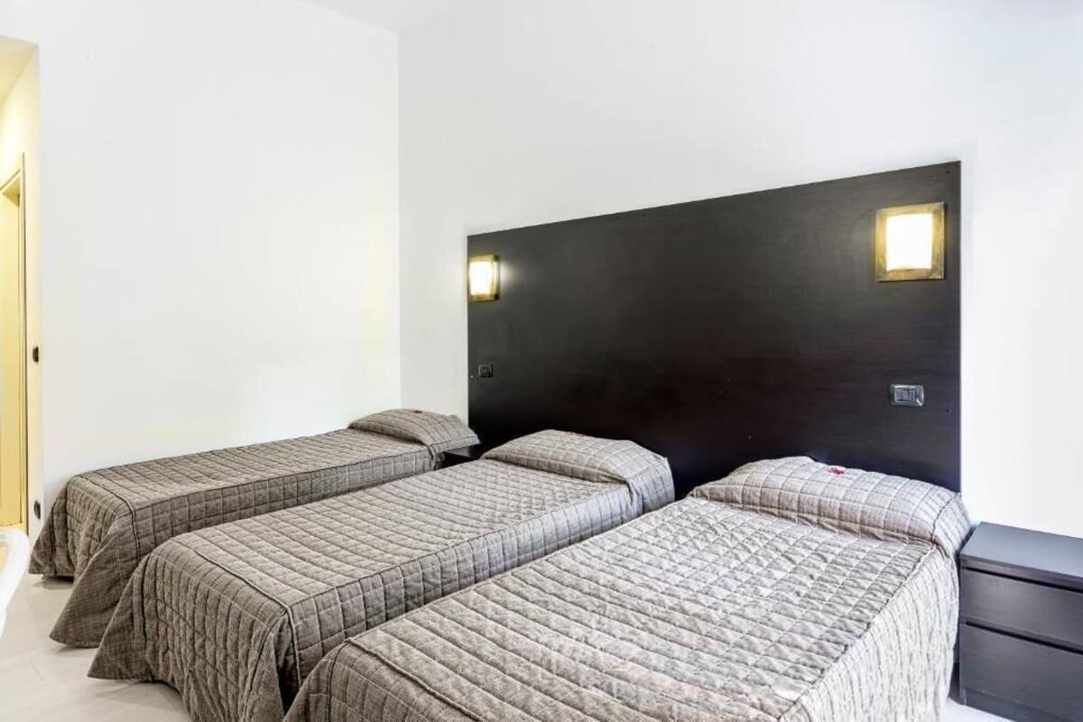 A room with two single beds, a dark headboard, and a small bedside table.