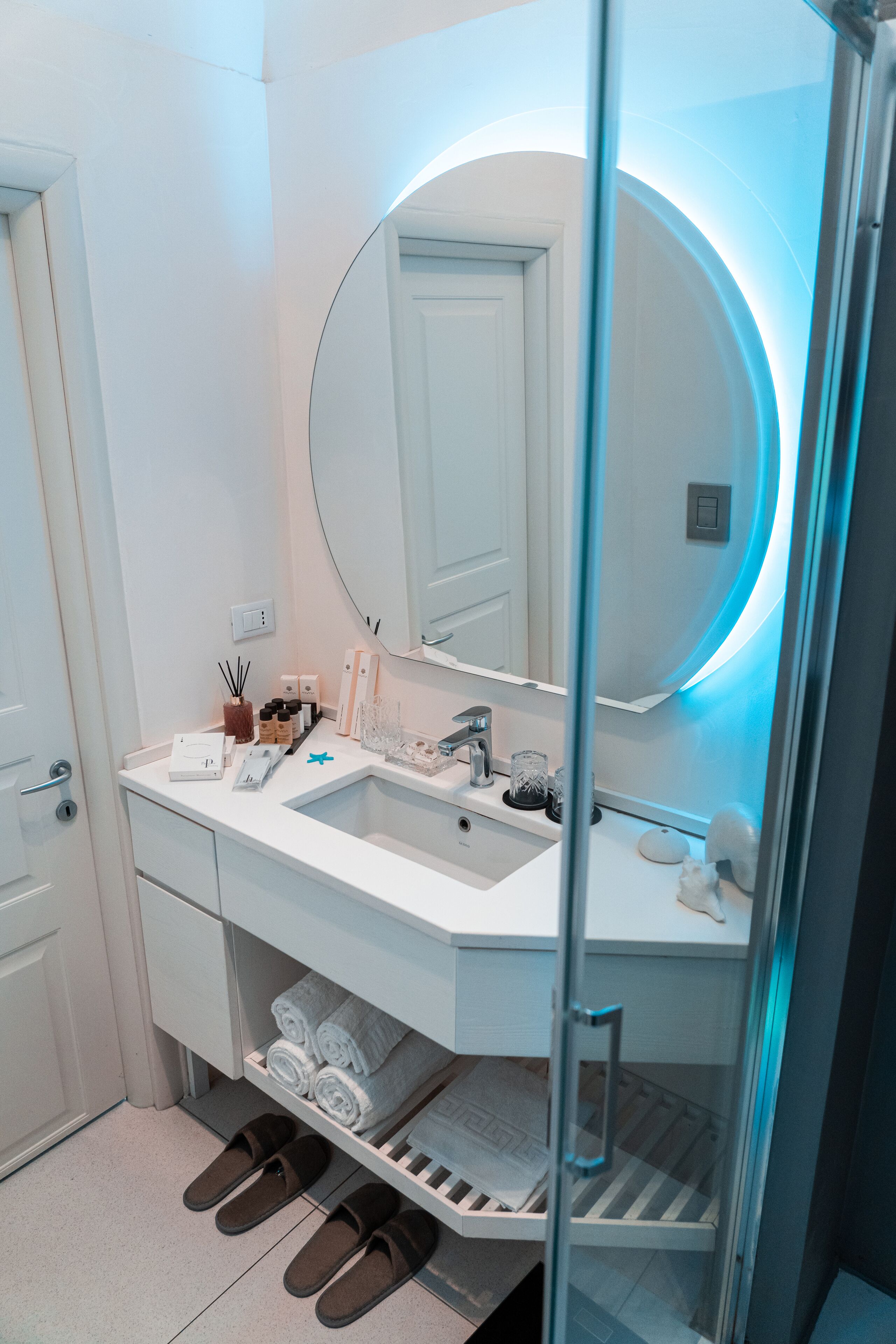 A modern bathroom with a white vanity, a large mirror, and a glass shower enclosure.