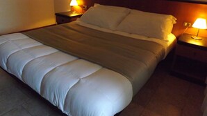A neatly made bed with white linens and a brown blanket, flanked by two bedside tables with lamps. - RTA Le Corti (Grosseto)