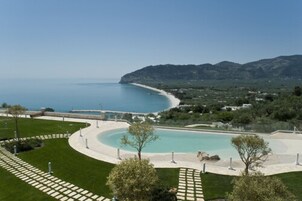 Una piscina al aire libre, sillones reclinables de piscina