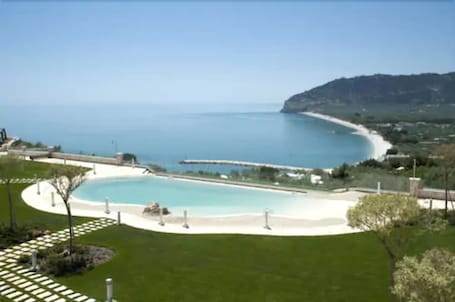 Una piscina al aire libre, sillones reclinables de piscina