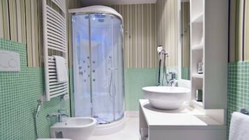 Une salle de bain avec une douche, deux lavabos, des toilettes et un porte-serviettes.